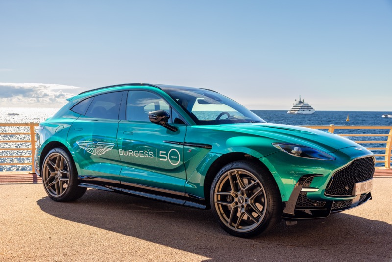 A turquoise Aston Martin DBX in Burgess Yachts fifty years livery on the Monaco waterfront
