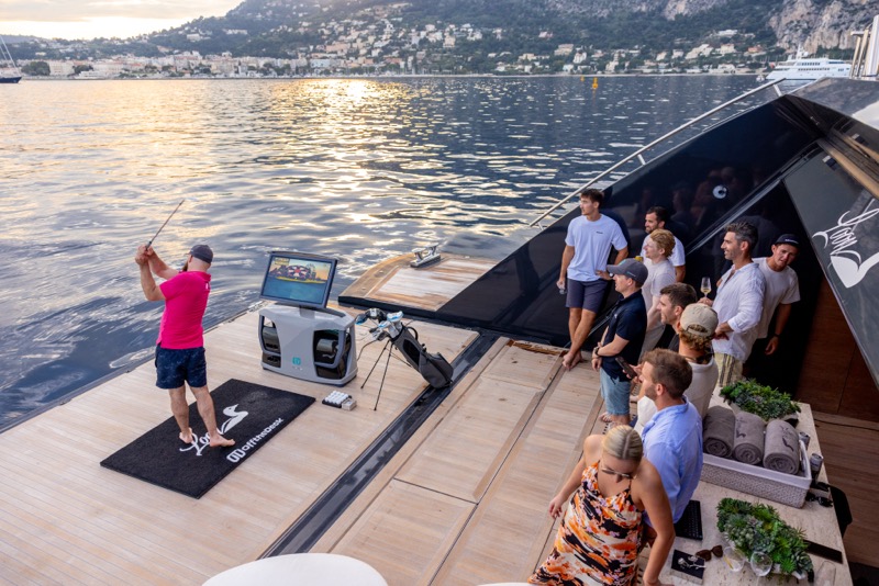 Guests gathered on the swim platform at sunset watching a drive