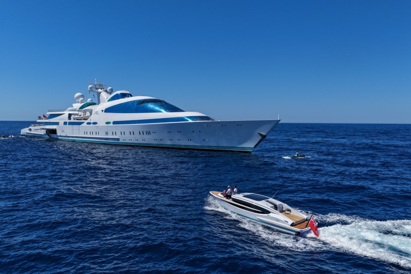 A Falcon tender running at speed in front of M/Y Yas