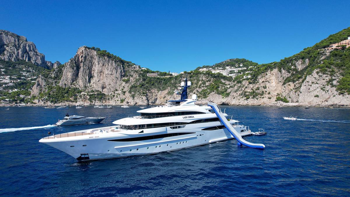 A white superyacht at anchor off the cliffs of Capri