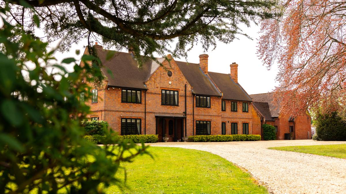 A country house listing photographed through mature trees