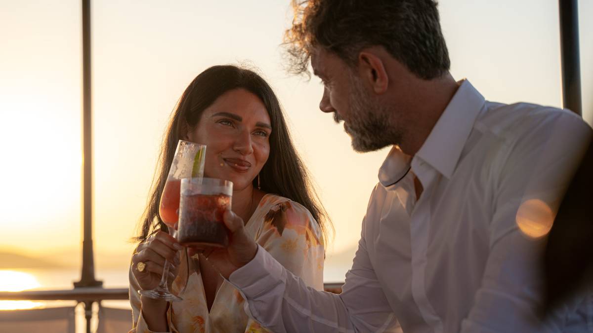 Two guests sharing a drink at sunset on a terrace
