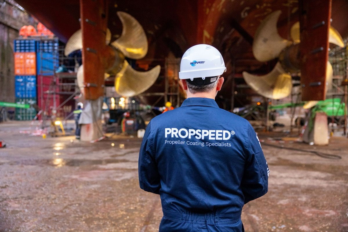 A Propspeed technician looking up at twin propellers in a dry dock