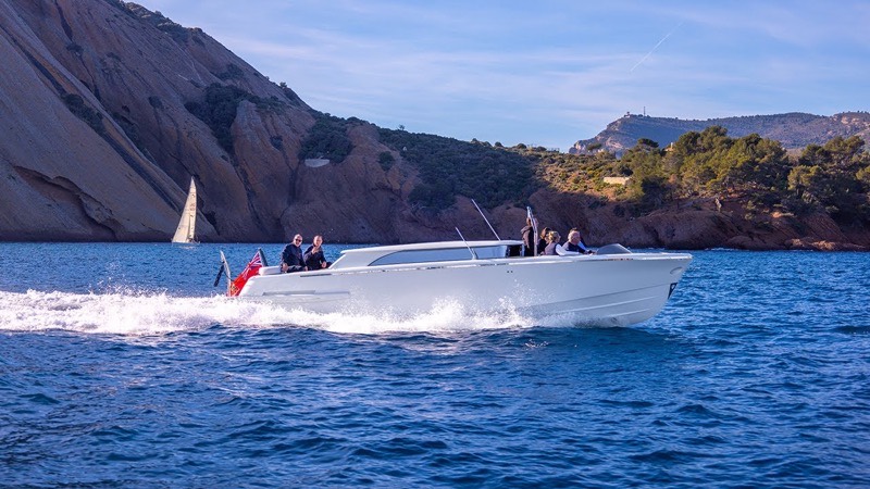 A tender running fast along a rocky Mediterranean coast