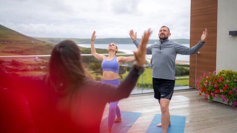 A yoga class on a decked terrace above the bay