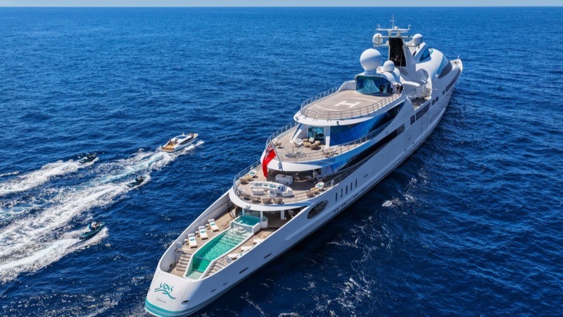 M/Y Yas under way in open water with a tender running alongside
